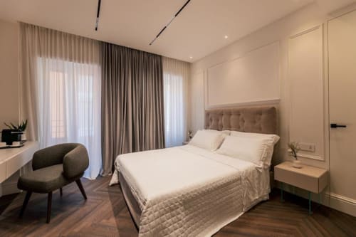 Camera moderna presso Domus Gaudia Rome con letto matrimoniale, scrivania, porte-finestre sul balcone e arredamento elegante dai toni neutri