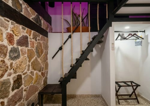 Modern staircase with rope railings in Villa Merida Boutique Hotel room, featuring stone walls and contemporary design