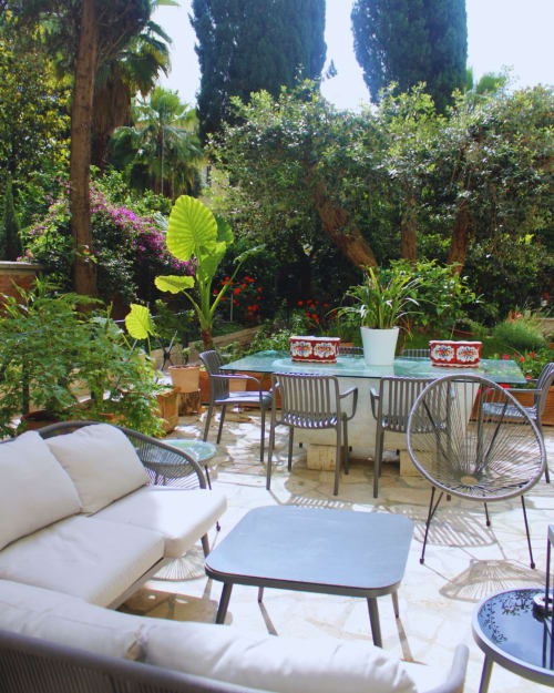 Lush garden terrace with dining table, loungers, and tropical plants at EppyTime Rome apartment