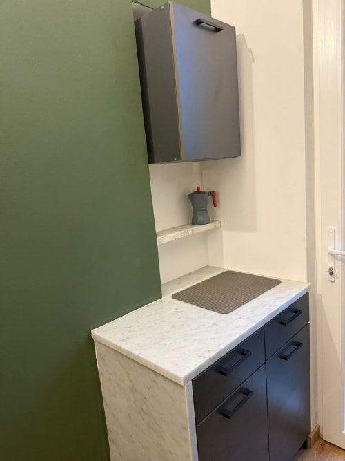Cucina moderna con top in marmo, mobili scuri e pensile a muro nell'appartamento Mistral Holidays a Marina