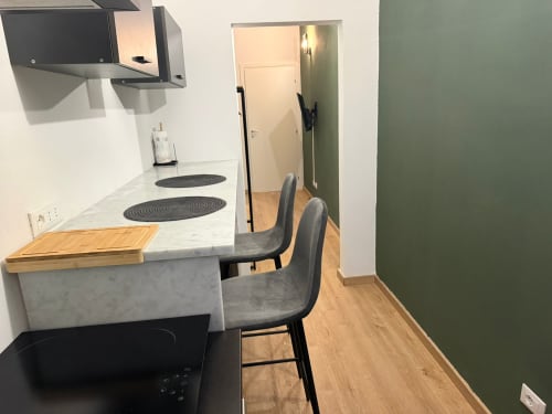 Cucina moderna con banco bar, fornello e due sedie nell'appartamento Mistral Holidays vicino a Marina di Carrara