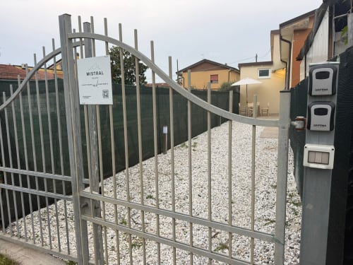 Ingresso recintato di Mistral Holidays con corte in ghiaia e stazione di ricarica a Marina di Carrara