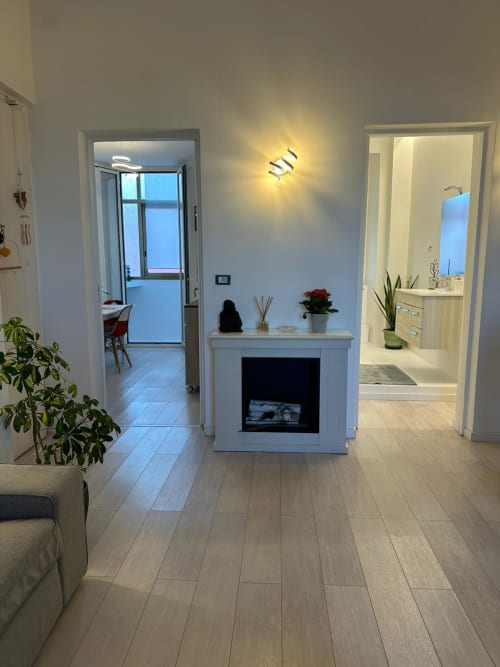Modern apartment living room at Aparthotel Bentivoglio Catania with fireplace, sea view balcony, and contemporary decor