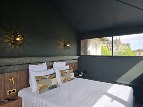 Modern bedroom at Le Castel B&B in Bayeux with cathedral views, dark walls, decorative lighting, and white bedding