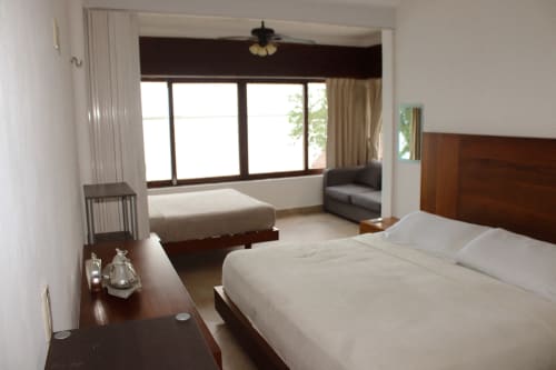 Espacioso dormitorio de villa en Tucan Village Bacalar con vista al lago, cama doble, sala de estar y terraza con vistas