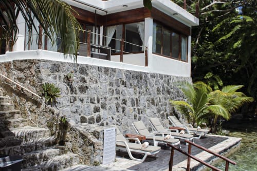 Villa frente al lago en Tucan Village, Bacalar con base de piedra, tumbonas, vista al lago y vegetación tropical