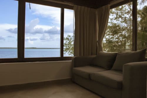 Villa frente a la laguna en Tucan Village, Bacalar, bañada por luz solar con mobiliario moderno y vistas al agua cristalina