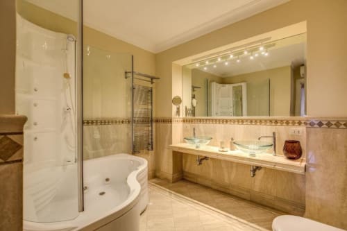 Bagno lussuoso in appartamento romano con doppio lavabo, vasca spa, cabina doccia, scaldarifiuti e vista sulla città