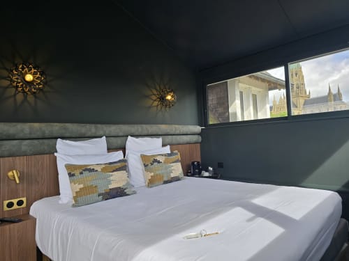 Modern bedroom at Le Castel B&B in Bayeux with cathedral views through windows and contemporary fixtures