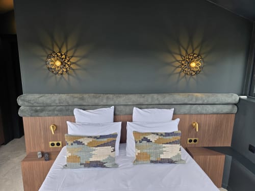 Chambre double moderne au Castel à Bayeux avec literie blanche, coussins géométriques et appliques murales dorées géométriques
