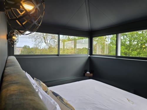Chambre moderne au Castel Bayeux avec baies panoramiques sur jardins verdoyants et paysages de campagne