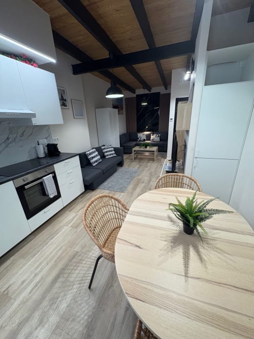 Apartamento moderno de planta abierta en Valencia con cocina, comedor y sala de estar con techo de vigas de madera