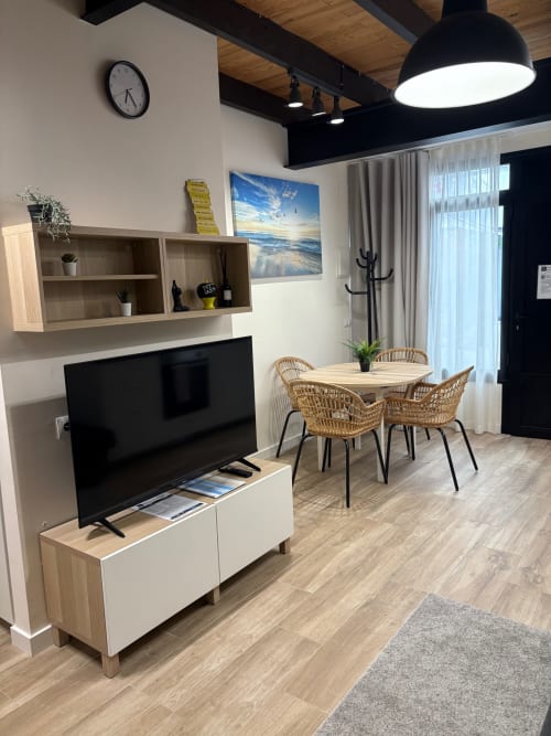 Salón moderno del apartamento Be Gonfre Flats en Valencia con televisor, comedor, muebles de madera e iluminación natural