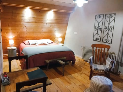 Chambre rustique en bois du gîte Paulusmühle à Soucht, France, avec éclairage chaleureux et mobilier traditionnel