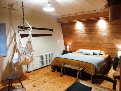 Chambre douillette à Paulusmühle avec murs en bois, chaise suspendue, lit et décor rustique à Soucht