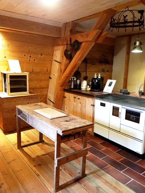 Cuisine rustique du cottage Paulusmühle à Soucht avec poutres en bois, table de travail, électroménagers blancs et décor traditionnel