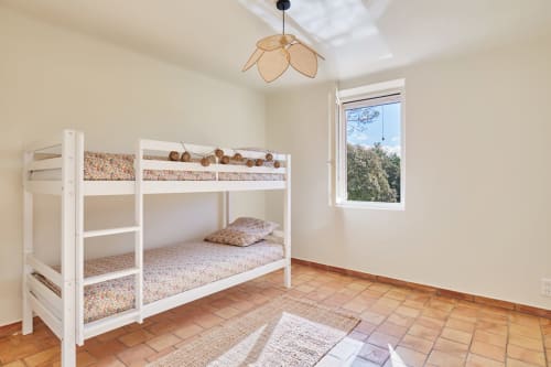 Chambre d'enfants lumineuse avec lits superposés blancs et linges à motifs à la villa CIRELINE à Rognes, avec puits de lumière