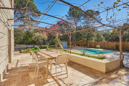 Terrasse de jardin avec table à manger, pergola et piscine à la villa CIRELINE-La Fontaine du Roy à Rognes, France