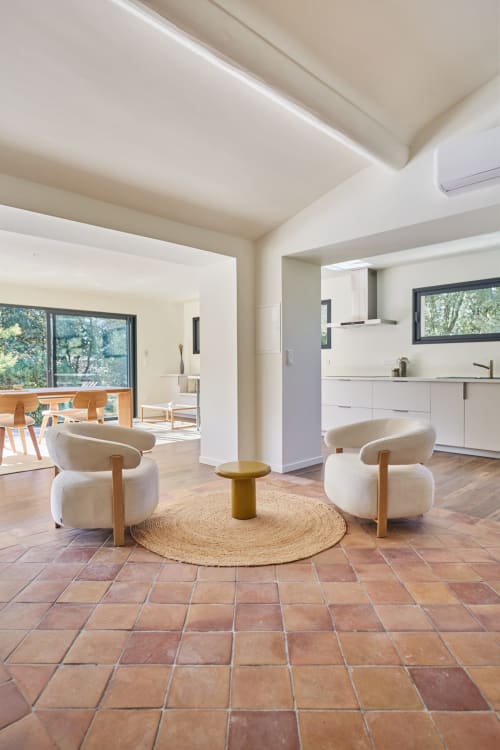 Salon de villa moderne avec fauteuils crème, carrelage terre cuite et vue sur le jardin à CIRELINE-La Fontaine du Roy, Rognes