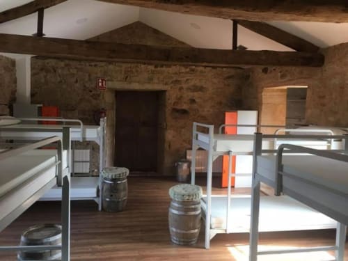 Habitación rústica en O Lagar De Jesus en Padrón con literas, muros de piedra vista y vigas de madera