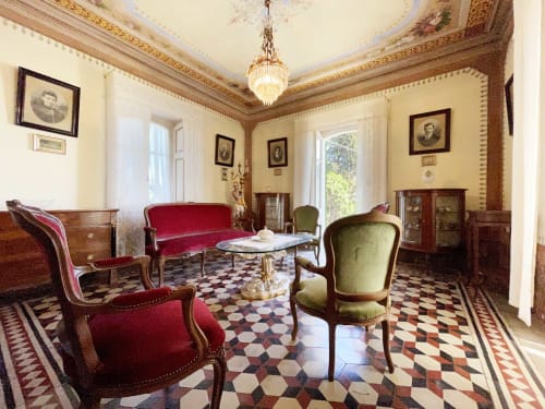 Elegant parlor at Lake Orta Retreat with red velvet furniture, checkered floor, and ornate ceiling in San Maurizio D'Opaglio