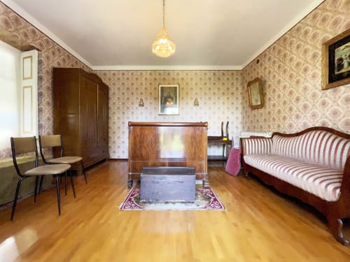 Historic bedroom at Lake Orta Retreat B&B in San Maurizio D'Opaglio with wooden furniture, patterned wallpaper, and hardwood