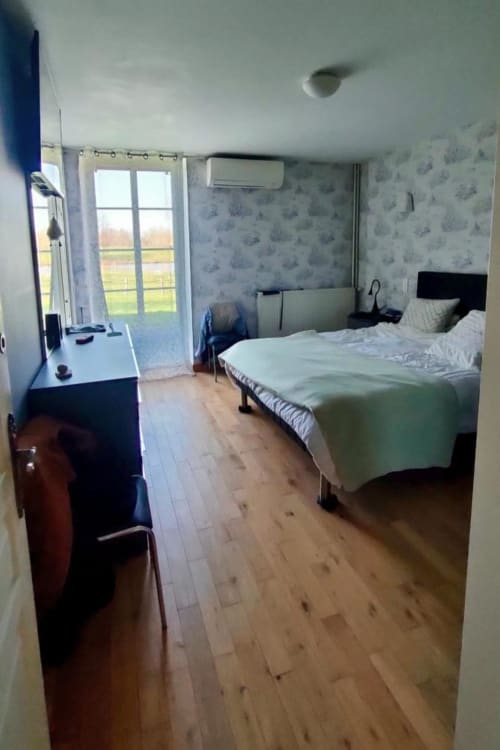 Spacious bedroom at Domaine de Beau Site with twin beds, patio doors, countryside views, and modern amenities