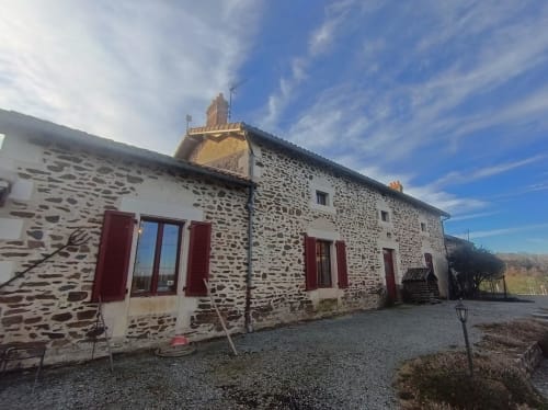 Domaine de Beau Site stone cottage with red shutters in Peyrat-de-Bellac, France