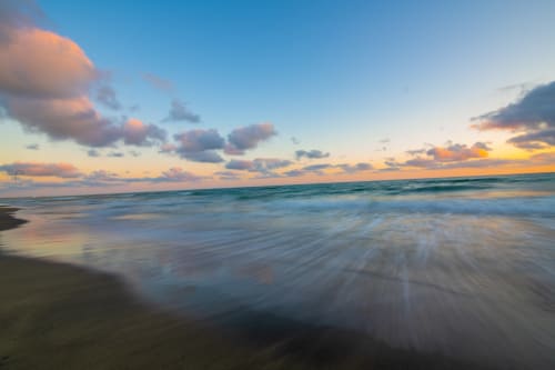 Tramonto su spiaggia dorata con onde delicate e sabbia vicino agli alloggi di Campagnano di Roma