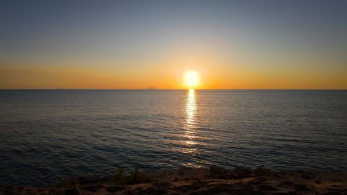 Tramonto sul Mar Mediterraneo a Travellers Homes, Campagnano di Roma, con cielo dorato riflesso sull'acqua