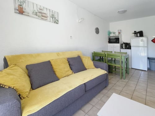 Canapé jaune avec coussins gris dans studio moderne au Vallon des Sources, Digne-les-Bains, kitchenette et