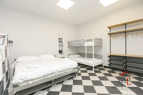 Camera dormitorio moderna a Genova con letti a castello, letto matrimoniale e pavimento a quadri