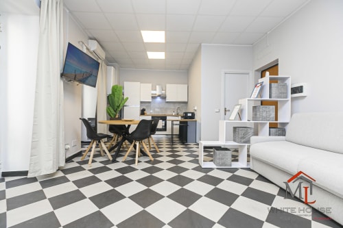 Appartamento White House a Genova con cucina aperta, zona living, camera da letto, TV e pavimento a scacchi bianco-nero