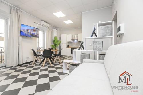 Elegante soggiorno di moderno appartamento a Genova con pavimento a scacchiera, zona pranzo, scaffali e vista del porto sulla TV