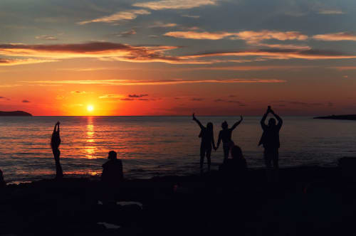 Sagome di persone che godono del tramonto sulla spiaggia vicino a Travellers Homes a Campagnano di Roma, Italia