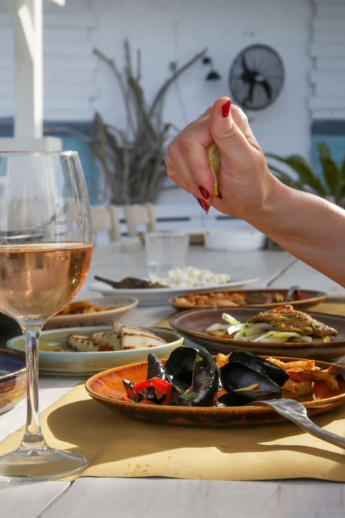 Donna che gusta la cena mediterranea con cozze e vino bianco a Travellers Homes, Campagnano di Roma