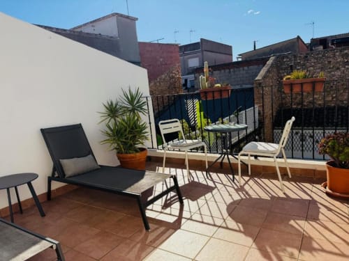 Sunny terrace at Casa Sibarita with lounge chairs, potted plants, and garden views of Rafelguaraf