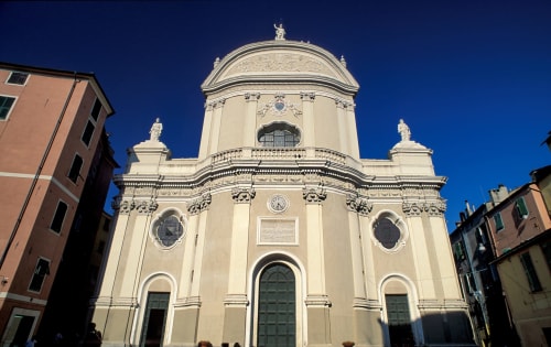 Chiesa neoclassica con cupola a Campagnano di Roma, facciata color crema e cielo azzurro