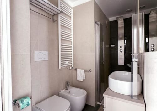 Moderno bagno della Junior Suite Hotel Vienna a Pesaro, con bidet, water, scaldasalviette e lavabo con specchio