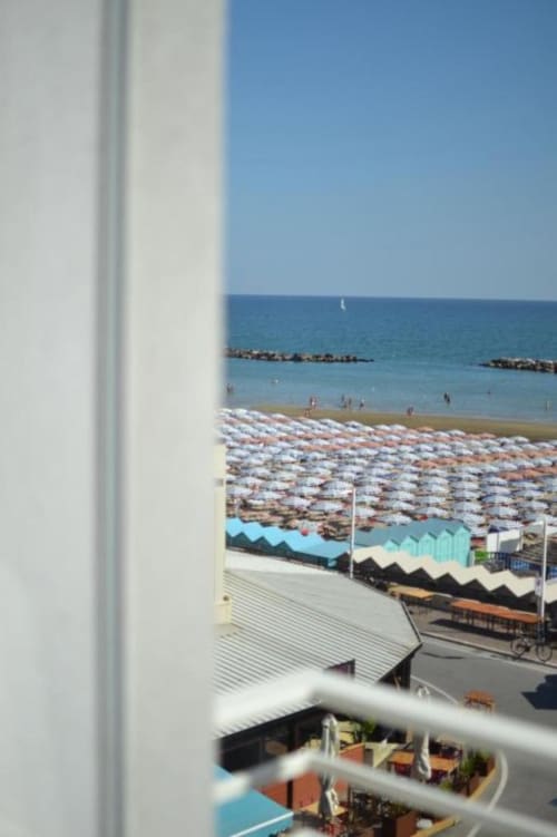 Vista della spiaggia di Pesaro dal balcone della Junior Suite dell'Hotel Vienna con le colorate cabine da spiaggia e il Mar Mediterraneo