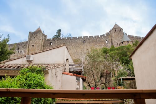 La forteresse médiévale de Carcassonne vue depuis la terrasse du gîte La Maison de Marcelo avec ses jardins luxuriants