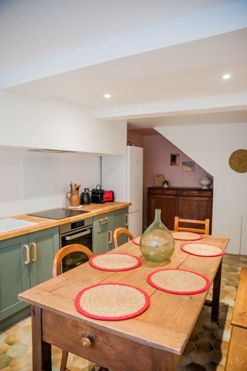 Cuisine et coin repas contemporain à Carcassonne avec mobilier vert, table en bois et sets de table rouges