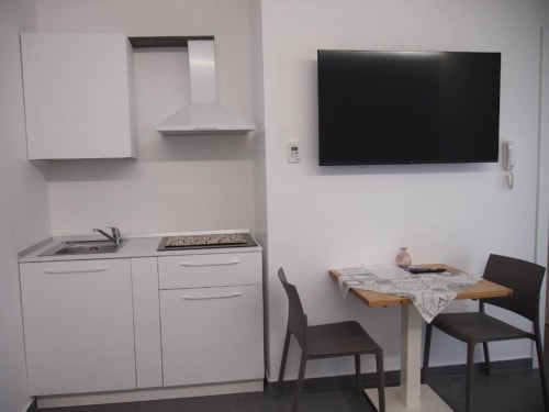 Junior Suite Hotel Vienna con angolo cottura, area pranzo, TV a parete e arredi moderni a Pesaro