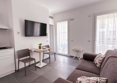 Junior Suite moderna all'Hotel Vienna di Pesaro con angolo cottura, zona pranzo, divano letto e balcone con vista mare