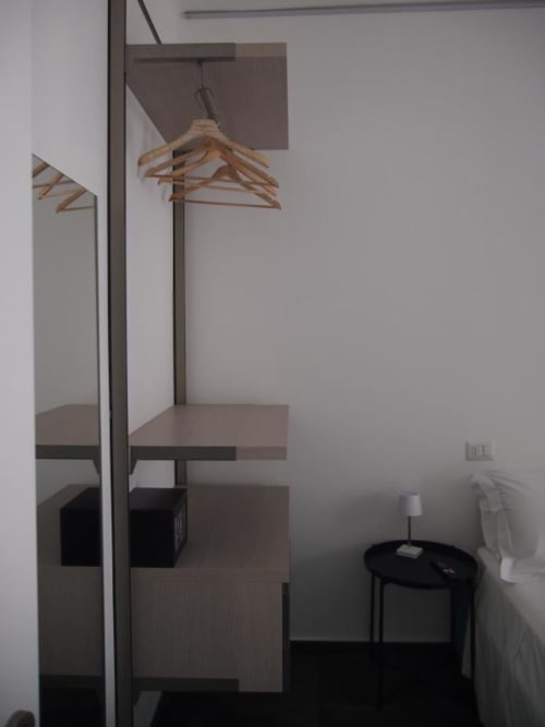 Appendiabiti in legno su portabiti nella suite junior dell'Hotel Vienna con angolo cottura e tavolino nero