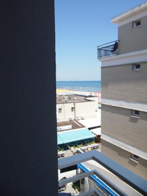 Vista dal balcone della Junior Suite dell'Hotel Vienna a Pesaro: spiaggia, mare e edifici limitrofi