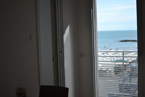 Luxus-Suite im Hotel Vienna in Pesaro mit Meerblick durch Glastüren und Strandbalkon über der Adria