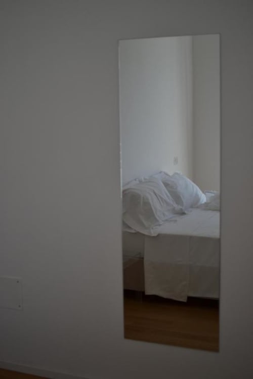 Spiegelreflexion des Bettes mit weißer Bettwäsche in der Hotel Vienna Superior Suite, Pesaro