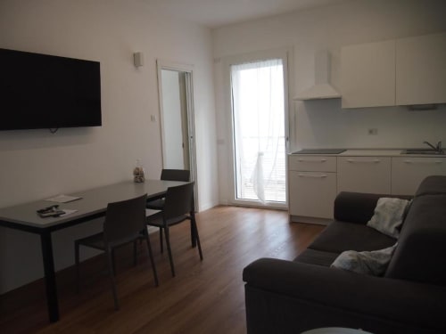 Moderne Superior Suite im Hotel Vienna in Pesaro mit Wohnbereich, schwarzem Sofa, Esstisch, Küchenzeile und Meerblick-Balkon