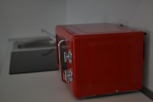 Piccolo frigorifero rosso nella kitchenette della Suite Superior dell'Hotel Vienna con elettrodomestici moderni e vista sulla città